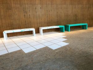 White and turquoise painted wooden benches stand in the Festspielhaus.