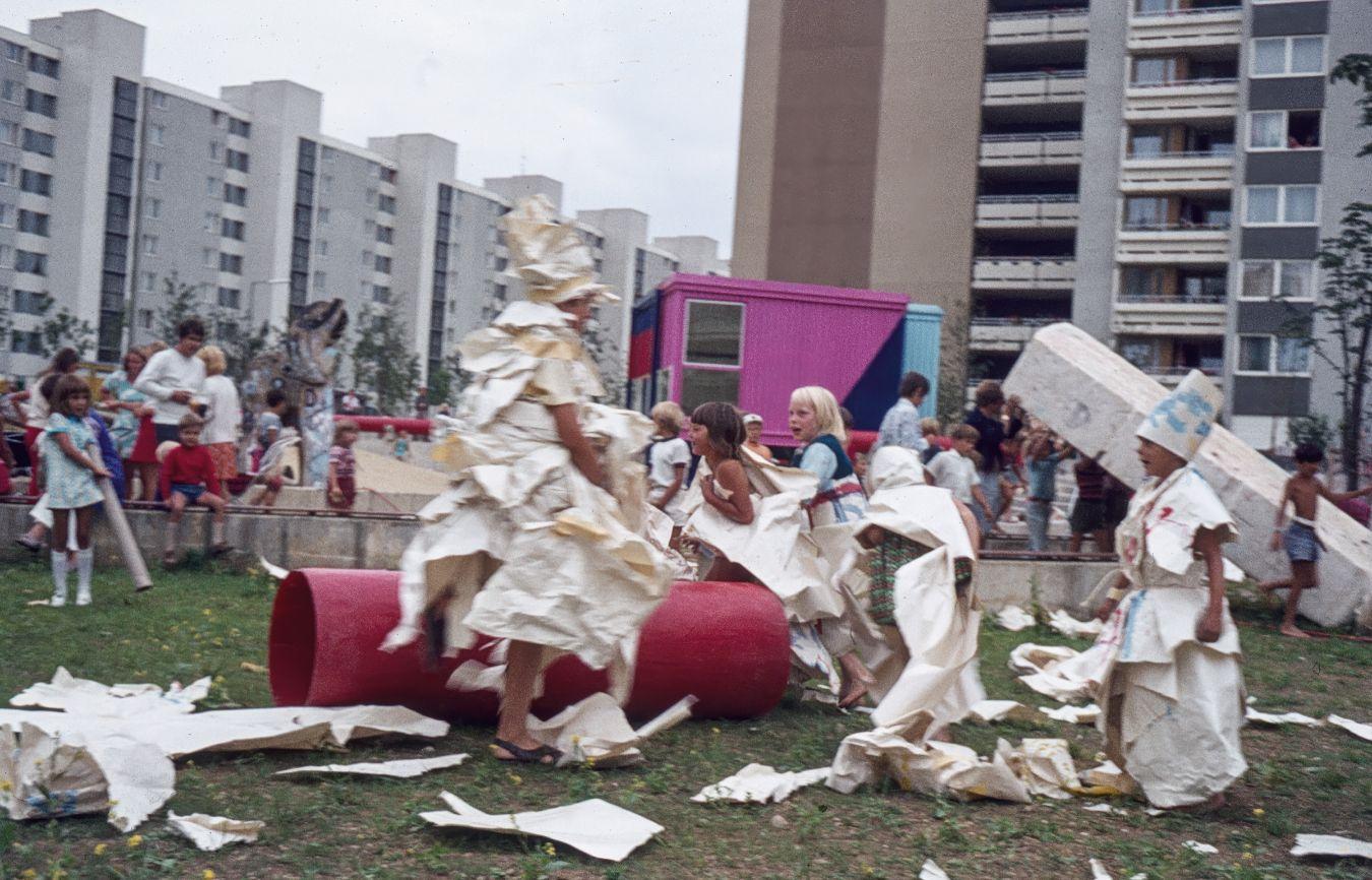 Kinder spielen zwischen Plattenbauten