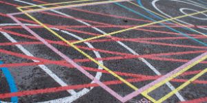 A pattern of coloured lines and circles on asphalt