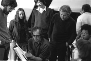 Frederic Rzewski is leafing through a score on a music stand. Other members of the CMS, including Karl Berger and George Lewis, stand and sit around him.