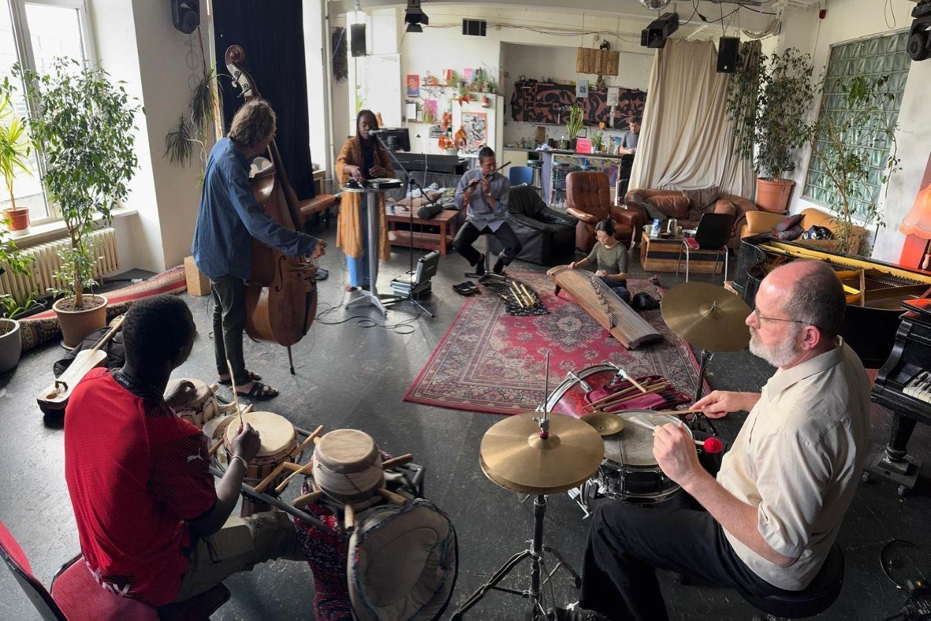 Musiker*innen spielen in einem Proberaum