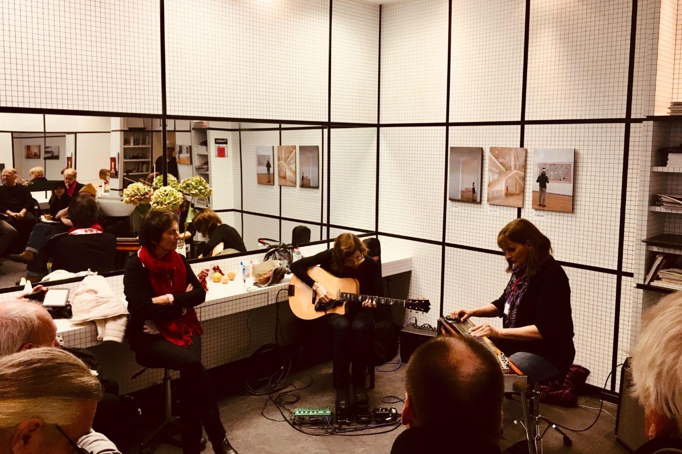 Zwei Musikerinnen spielen in einem Friseursalon auf ihren Instrumenten.