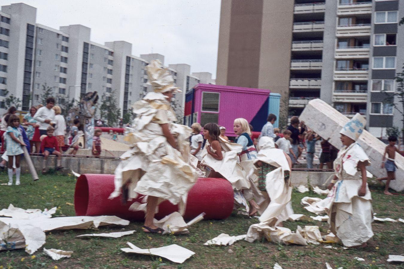 Kinder spielen zwischen Plattenbauten