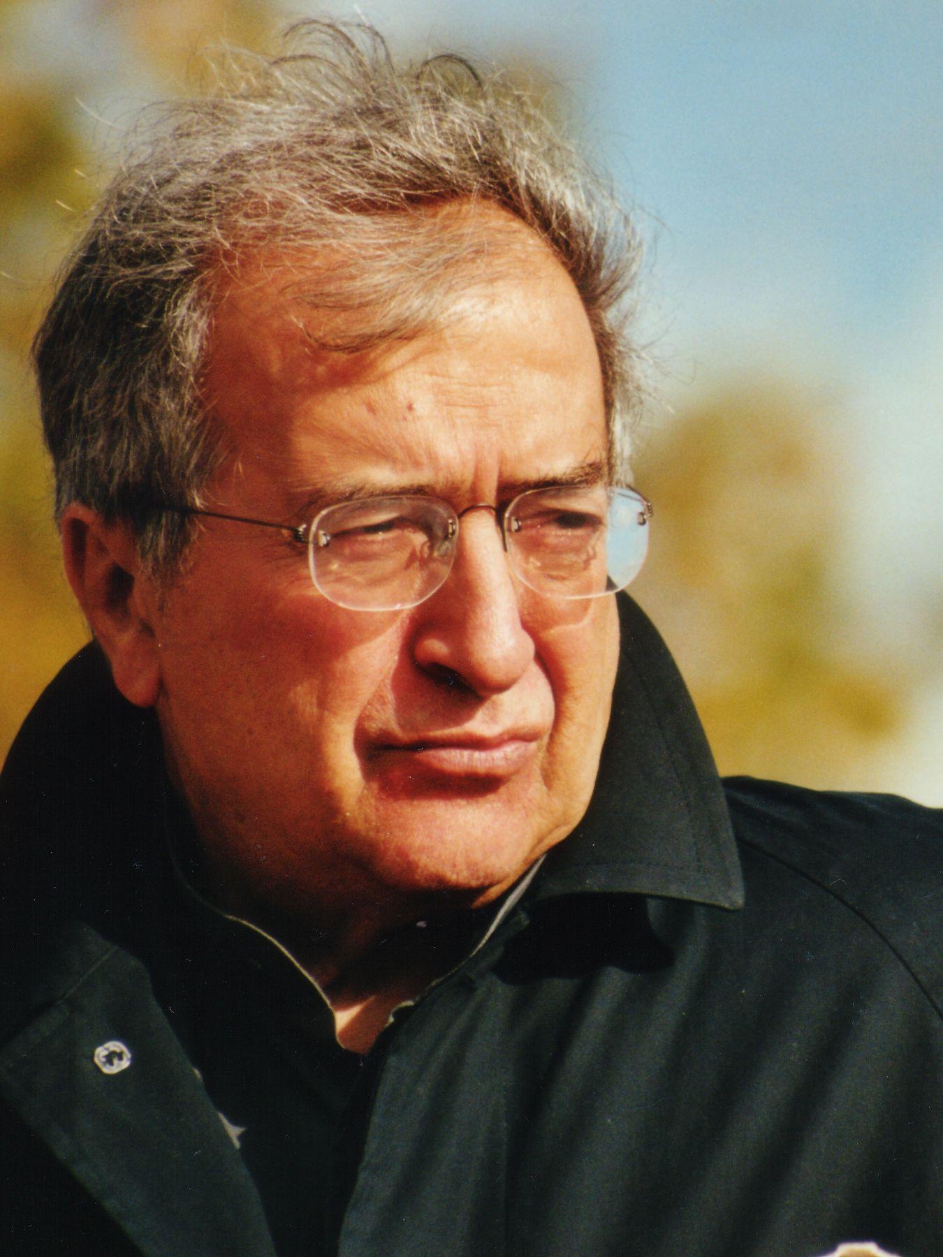 Portrait of a man in front of an autumn tree, wind is blowing through his hair.
