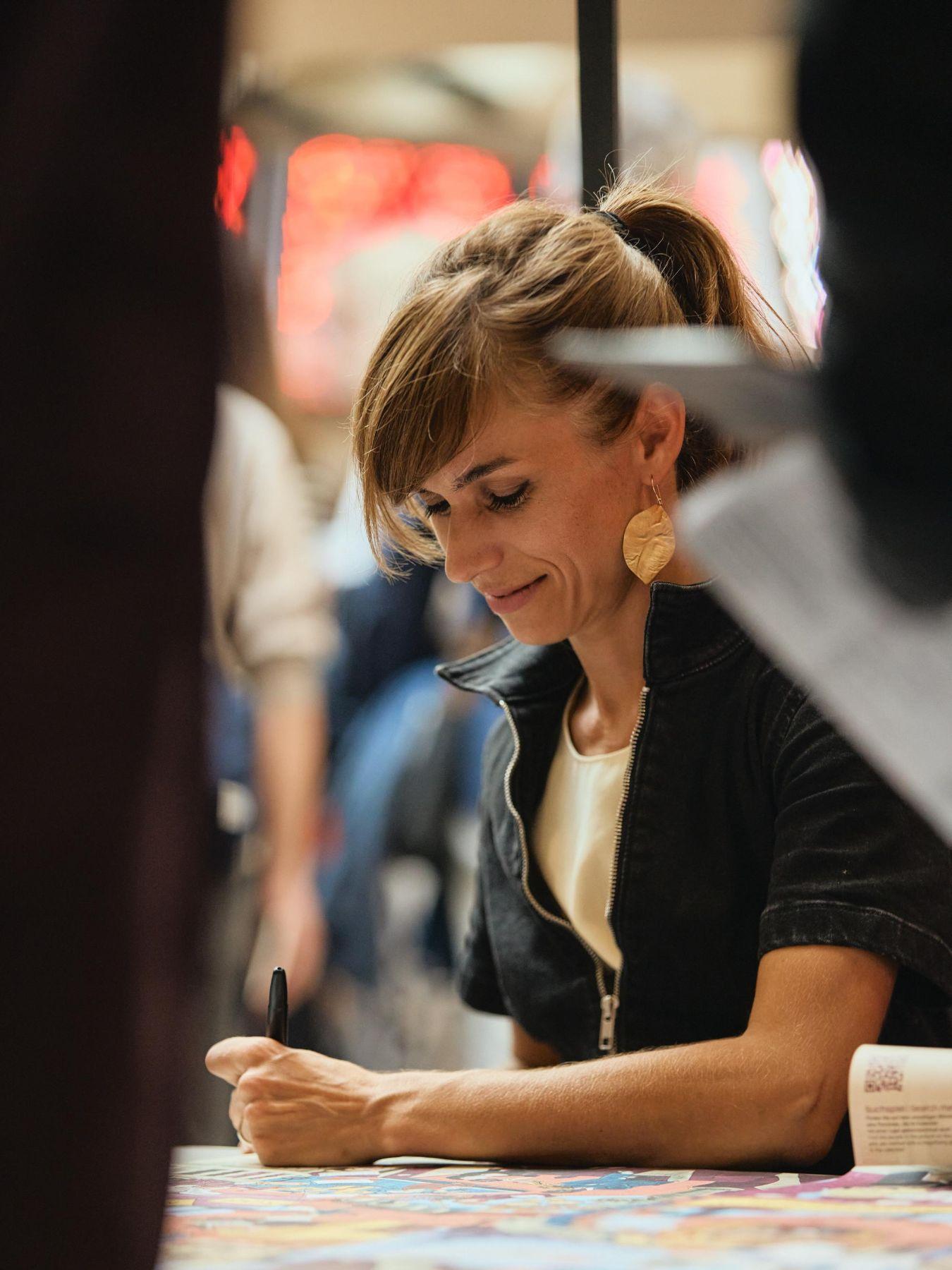Photograph with Alexandra Klobouk, signing prints of the hidden object poster.