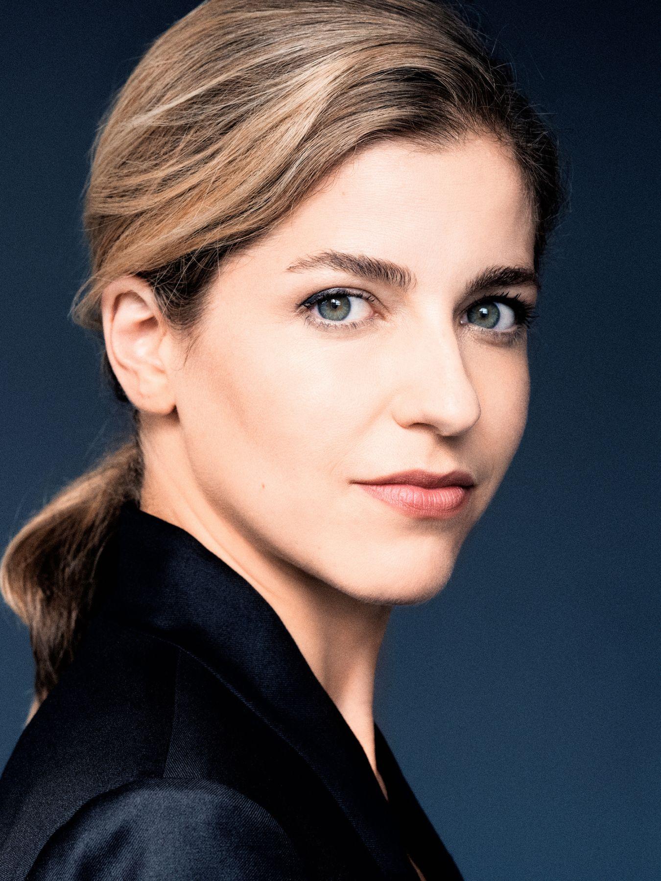 A woman looking over her right shoulder into the camera.