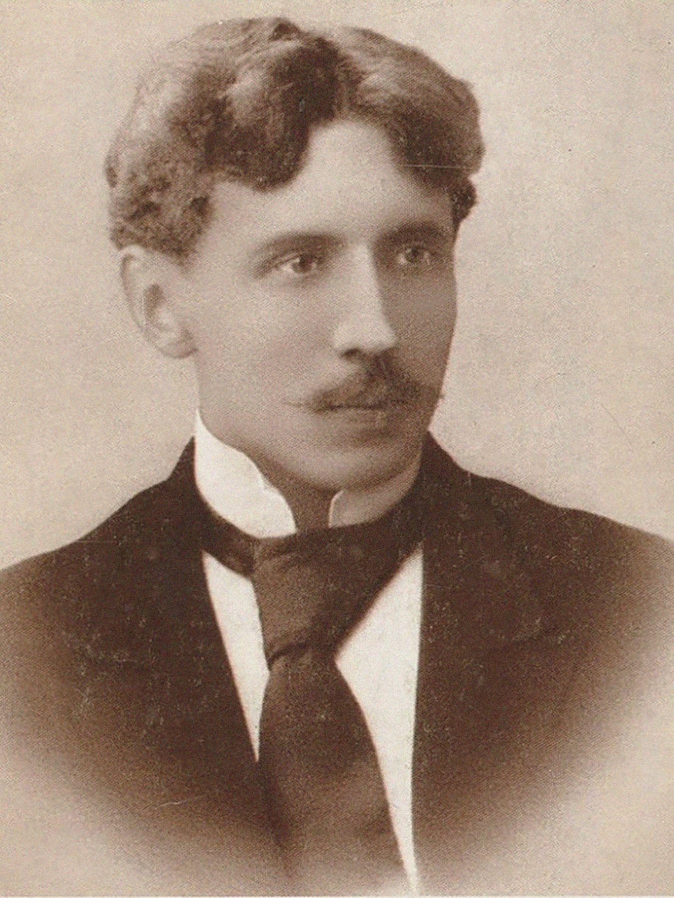 Vignetted sepia portrait of a man in a suit.