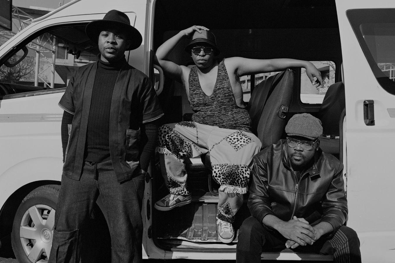 Musicians from the ensemble The Brother Moves On pose in front of a minibus.