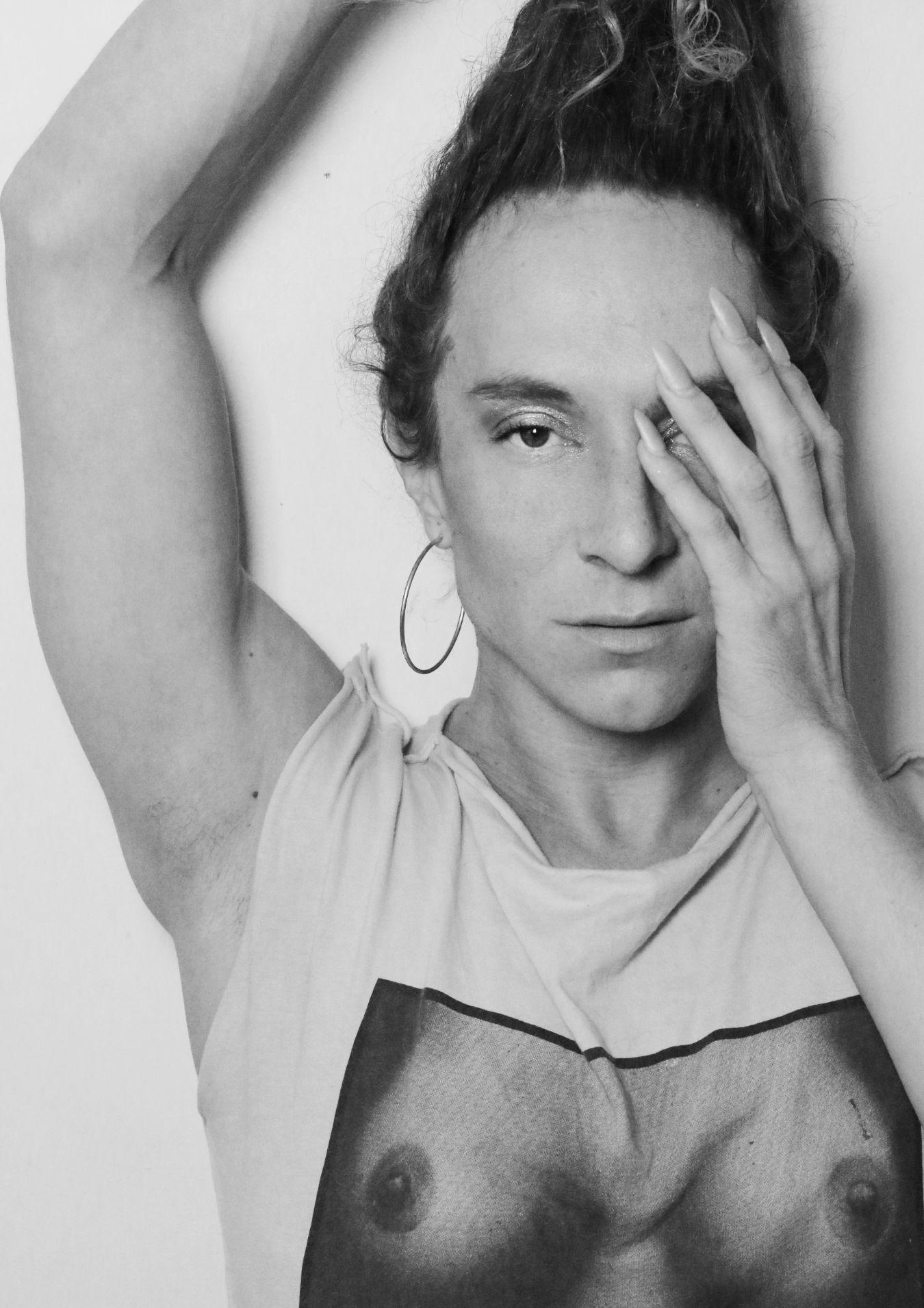 Chaignaud hält eine Hand mit langen Fingernägeln über eine Gesichtshälfte.