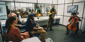 An ensemble plays in a tiled room with many mirrors