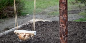 Eine Schaukel mit einem Holzklotz als Sitzfläche