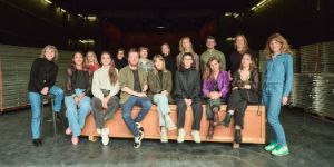 A group of people sitting on a large wooden box