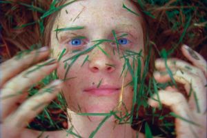 A woman throws cut grass in her face.