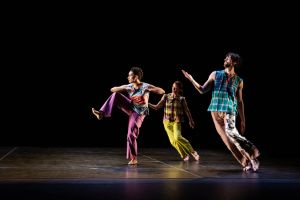 Three dancers from the Trisha Brown Dance Company on stage