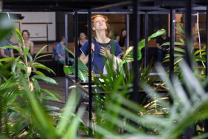 A woman stands in front of plants in the Gropius Bau.