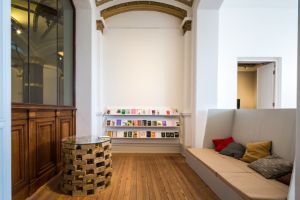 A room with a reading bench and a bookcase