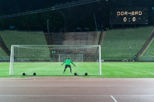 Ein Torwart in einem Tor vor einem leeren Stadion