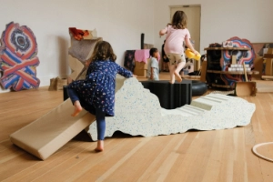 Children play in a room with colourful structures.