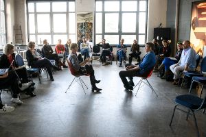 A group of people are discussing in a circle.