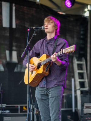 Mathis Schuller mit seiner Gitarre auf der Bühne.