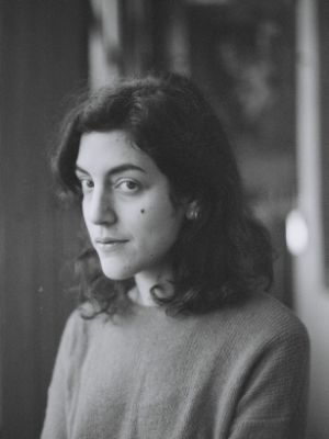 A black and white portrait of a dark hair women facing the camera at a 3/4 angle while looking at the lens.