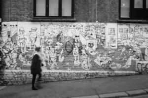 Frau vor einer Backsteinwand mit gezeichneten Graffiti