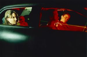 Vier Personen in einem Auto, in grün und rot belichtet