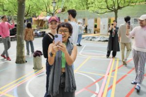 Teilnehmer*innen des Internationalen Forum 2024 erkunden mit ihren Smartphones das Gelände von „Radical Playgrounds“ am Gropius Bau.