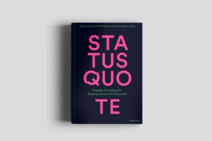 The book “Status Quote” lies on a wooden surface