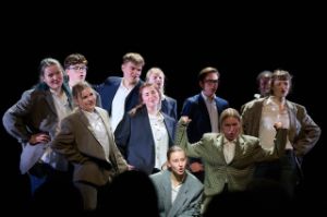 A group of young people poses in grey and blue jackets.